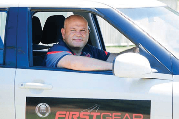 Friendly driving instructor from First Gear Driving Schools picking up a student for a driving lesson on the Gold Coast