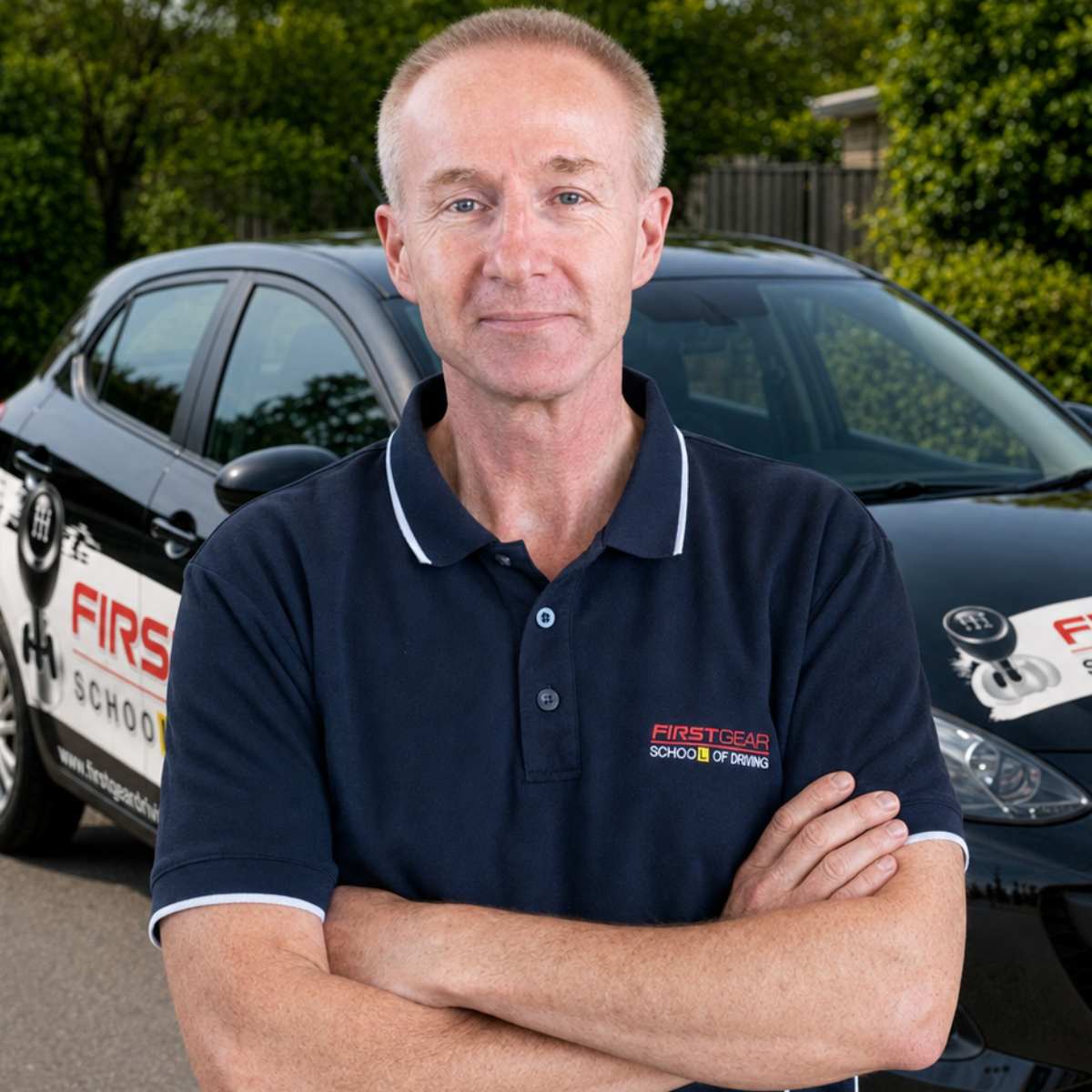 Kevin, First Gear Driving instructor, standing in front of his driving-school vehicle